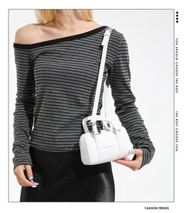 Close-up of a white Boston bag showing its textured faux leather and metallic silver zippers