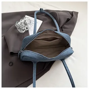 Overhead view of blue denim tote bag interior showing brown lining and storage pockets