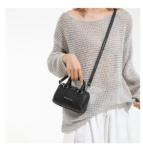 Detail of black pebbled leather Boston bag showing handle and Fashion & Bags text logo