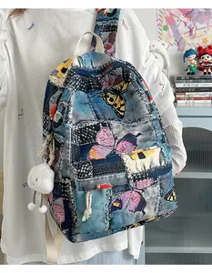 Close-up of mini backpack with denim patchwork, butterfly prints and cloud pendant
