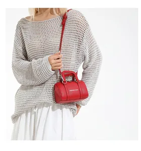 Detail of red Boston bag with pebbled leather texture and silver fashion metal buckle