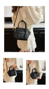 Detail of matte black PU leather mini handbag with top handle and magnetic buckle closure