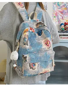 Detail view of woven jacquard mini backpack with colorful butterfly patterns and cloud charm