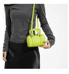 Detail of lime green mini Boston bag featuring litchi texture and silver hardware accents