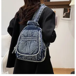 Detail of vintage blue denim backpack with washed texture and adjustable wide straps