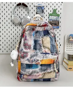 Detail of bohemian patchwork mini backpack with fringe and plush cloud charm accessory