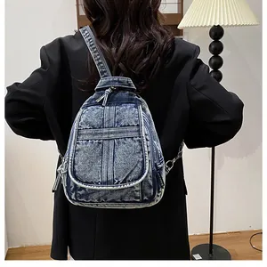 Detail of blue denim backpack with vintage washed finish and side fabric label details