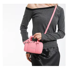 Close-up of pink mini Boston bag with textured leather and FASHION & BAGS lettering