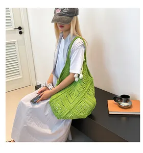 Detalle de bolso tote de ganchillo verde con malla de diamantes y colgante de tulipán