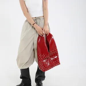 Sac fourre-tout tendance en cuir verni rouge avec clous argentés, style minimaliste