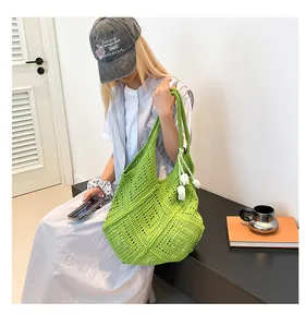 Detalle del bolso tote de ganchillo verde con textura tejida y dijes de tulipanes