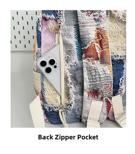 Close-up of back zipper pocket on denim patchwork backpack fitting a smartphone