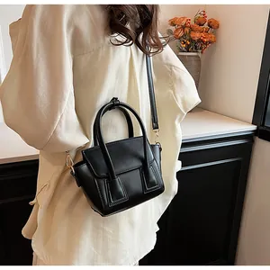 Detail view of a black PU leather handbag showing the flip cover and square texture