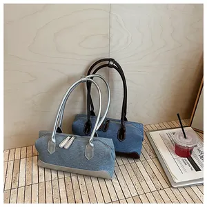 Détail de sacs à main shell en denim vintage bleu clair et bleu foncé avec garniture en cuir