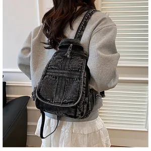 Detail of adjustable straps and washed denim texture on a black vintage backpack