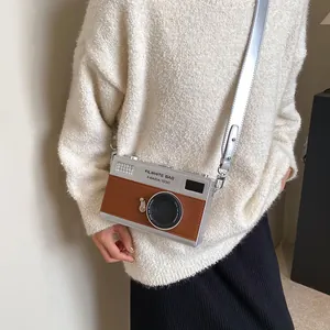 Retro camera-shaped crossbody bag with silver metallic finish and brown leather trim