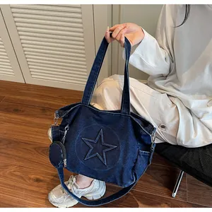 Detailed macro view of dark blue denim tote bag with star embossing and mini coin purse