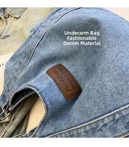 Close-up of blue denim shoulder bag with brown leather patch and precision stitching