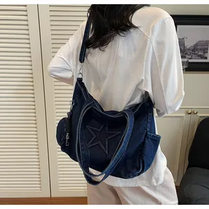 Detail of blue denim tote bag featuring star stitching and detachable round coin purse