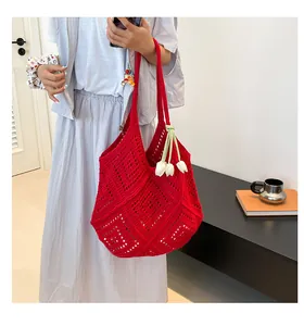 Detalle del bolso tote rojo de ganchillo con colgante de tulipán y correa ancha