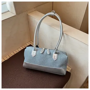 Détail du sac coquille en tissu gris avec poignées argentées et double fermeture éclair