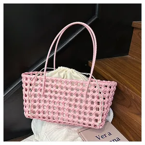 Détail d'un sac panier tressé rose avec une pochette intérieure à cordon blanc cassé