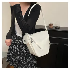 Detail of creamy white PU leather crossbody bag with front zipper and mini pouch attachment