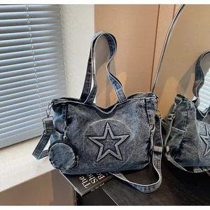 Detail of blue denim tote bag with star patch showing detachable strap and small round pouch