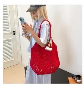 Detalle del bolso tote rojo de ganchillo con intrincados calados y adornos de flores blancas