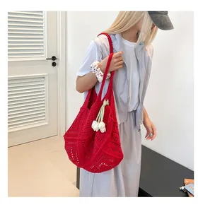 Vista detallada de un bolso tote de ganchillo rojo con un elegante colgante de tulipán