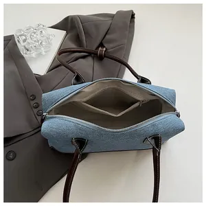 Détail du sac à main en denim avec poignées en cuir et poche intérieure zippée