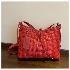 Detailansicht der roten geflochtenen Ledertasche mit feiner Textur und Bodenstollen