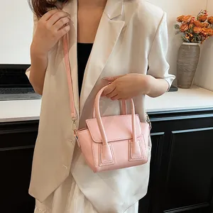 Elegant light pink mini handbag with top handle and adjustable strap for women