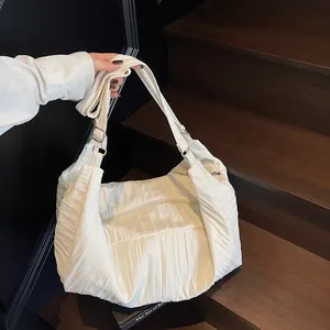 White oversized pleated hobo bag with quilted texture and adjustable strap for casual style