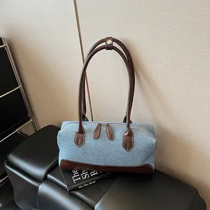 Sac bandoulière en denim bleu et cuir marron avec double fermeture éclair