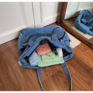 Top view of denim tote bag capacity showing tablet, umbrella and pink wallet inside