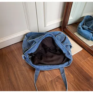 Detail view of denim tote bag showing interior lining, inner pockets and zipper closure