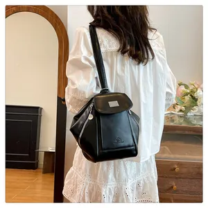 Rear view of model wearing a stylish black leather backpack with silver metal buckle