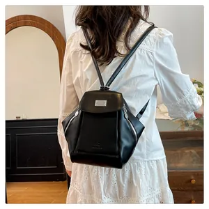 Detail shot of a black vintage backpack with silver zippers and elegant flap cover