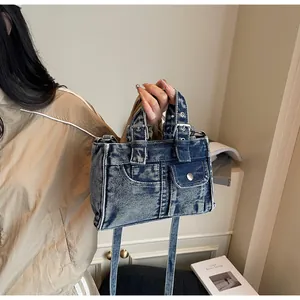Détail du sac moto en jean vintage montrant la texture délavée et les poches pratiques