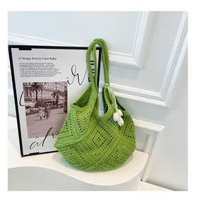 Vista detallada del bolso tote de ganchillo verde hierba con un dije de tulipán