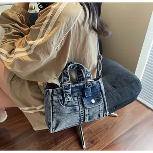 Détail du sac à main rétro en jean délavé avec surpiqûres blanches et rivets en métal