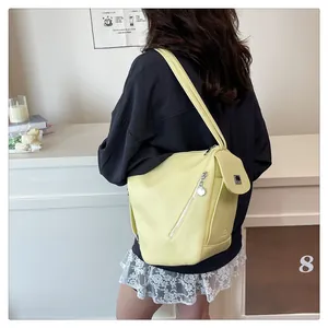 Detail view of cream multi-pocket backpack with silver zippers and magnetic flap closure