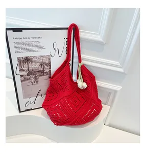 Detalle de bolso tote de ganchillo rojo con patrones geométricos y colgante de tulipán