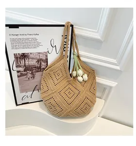 Detalle del patrón geométrico hueco tejido a mano en un bolso tote de verano beige