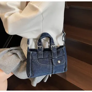 Détails du sac à main en jean bleu vintage avec surpiqûres et boucles métalliques