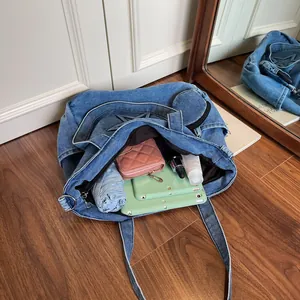 Large denim tote bag with star stitching shown from above with daily essentials