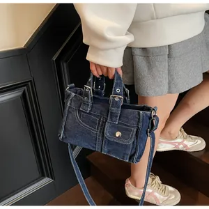Détail du sac à main vintage en jean bleu avec boucles de ceinture et bandoulière