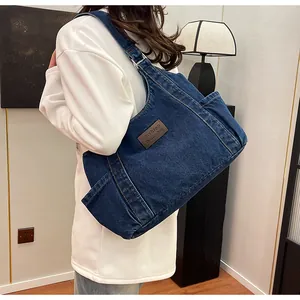 Detail of blue denim tote bag showing leather patch and textured washed canvas fabric