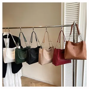 Detail view of woven texture tote bags in six colors with chain straps and metal logo